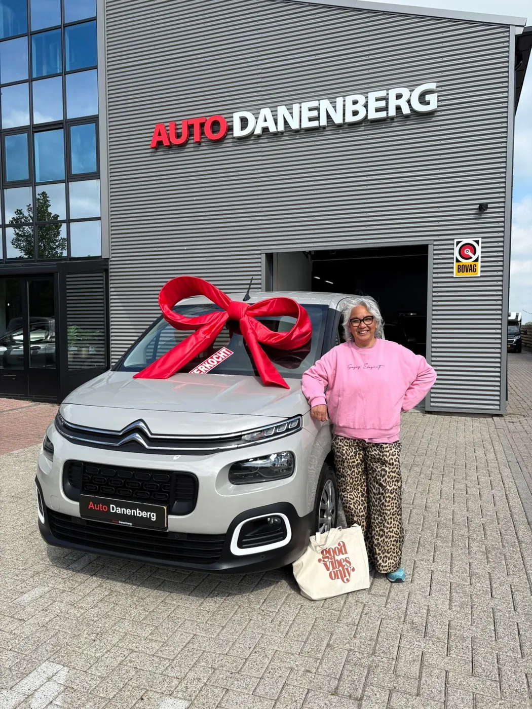 Klant met haar nieuwe Citroën voor het pand van Auto Danenberg